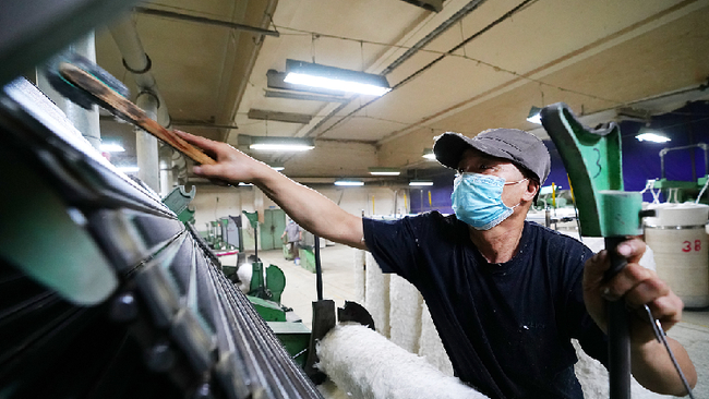 Një punonjës duke mirëmbajtur pajisjet në një fabrikë pambuku në Hami të Rajonit Autonom të Xinjiang-Ujgurit, Kinë, 14 mars 2022. /CFP