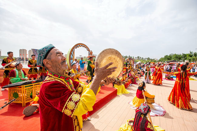 Artistët vendorë japin shfaqje artistike për turistët, 16 qershor 2022, Kuqa, Xinjiang(Foto:VCG)