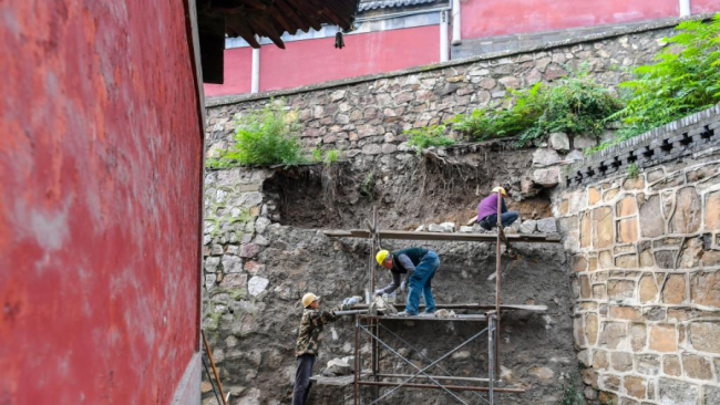 Snímek: Stavební dělníci opravují bariérovou zeď před chrámem Jinci (Ťin-c´) v provincii Shanxi, v severní Číně; 12. října 2021. / Xinhua
