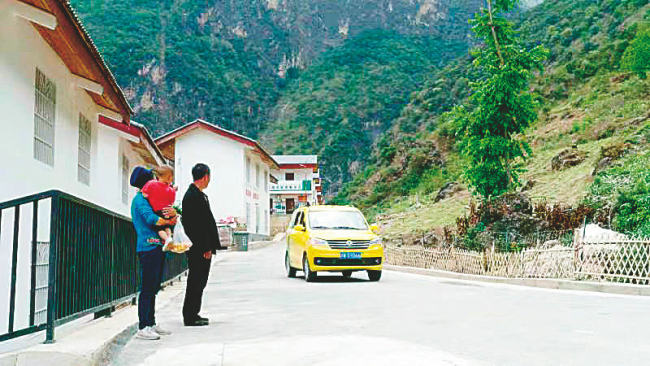 Někteří vesničané si koupili auto a pracují jako řidiči, protože cesta byla zpevněna. [Fotografie: Erik Nilsson / Deník China Daily]