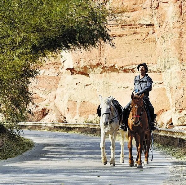 Zheng Jingtai (Čeng Ťing-tchaj) jede na koni kaňonem v provincii Gansu (Kan-su). [Fotografii poskytl deník China Daily]