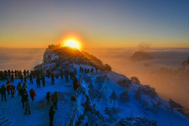 Turisté sledují východ slunce ve Žlutých horách, 5. června 2022. [Fotografie: tisková agentura Nová Čína / Xinhua]