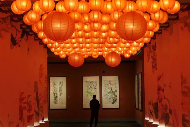 Un visiteur admire des peintures lors d'une exposition sur le thème du tigre tenue au Musée national de Chine, à Beijing, le 19 janvier 2022.