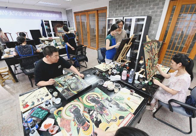 Οι καλλιτέχνες του Ινστιτούτου Έρευνας Τέχνης της Λάκας Φουτζιέν Χονγκμέν, δημιουργούν έργα με λάκα, στις 27 Ιουλίου. [Φωτογραφία/Xinhua]