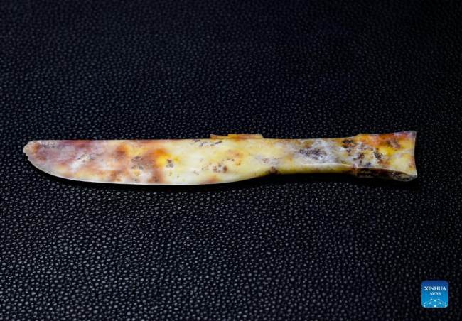 Η φωτογραφία που τραβήχτηκε στις 3 Σεπτεμβρίου 2021 δείχνει ένα μαχαίρι από νεφρίτη που ανακαλύφθηκε στο Νο. 6 λάκκο θυσιών του αρχαιολογικού χώρου Ερειπίων Σανσινγκντουέι στην επαρχία Σιτσουάν της νοτιοδυτικής Κίνας. (φωτογραφία / Xinhua)