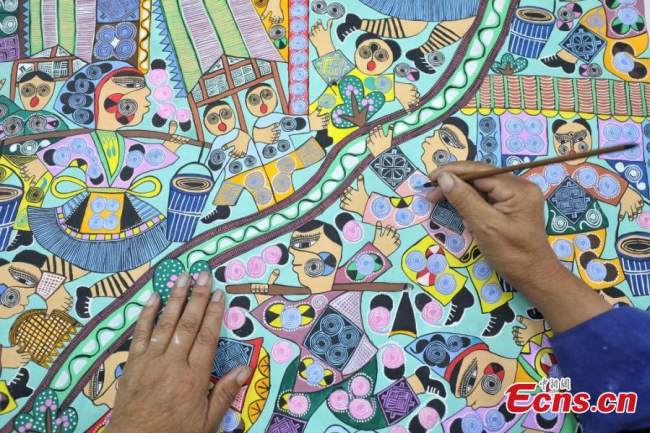 Ζωγράφος(画家Huàjiā )της εθνότητας των Μιάο ζωγραφίζει στο χωριό Πινγκπό της κομητείας Λονγκλί της Αυτόνομης Νομαρχίας Τσιεννάν Μπουγί και Μιάο, στην επαρχία Γκουιτζόου της νοτιοδυτικής Κίνας, στις 15 Σεπτεμβρίου 2021