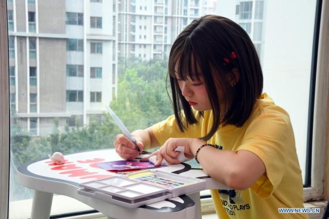 Η Τζανγκ Τζινγιουέ ενώ σχεδιάζει στο σπίτι της στο Πεκίνο, πρωτεύουσα της Κίνας, σε φωτογραφία από τις 8 Αυγούστου 2021. [φωτογραφία / Xinhua]