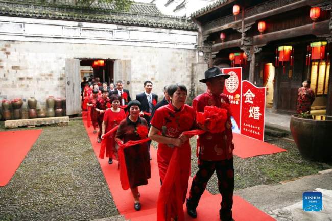 Ηλικιωμένα ζευγάρια συμμετέχουν σε μια συλλογική τελετή για να γιορτάσουν τη χρυσή επέτειο του γάμου τους στο χωριό Τζενσί της πόλης Ντονγκγιάνγκ στην επαρχία Τζετζιάνγκ της ανατολικής Κίνας, 12 Οκτωβρίου 2021. 