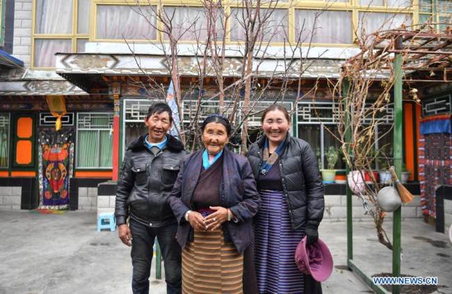 Η Ντάουα (κέντρο) ποζάρει για φωτογραφίες με τον γιο και την κόρη της στην αυλή της στην Κοινότητα Κεσούμ της πόλης Σανάν, στην Αυτόνομη Περιοχή του Θιβέτ της νοτιοδυτικής Κίνας, 15 Μαρτίου 2021. [φωτογραφία / Xinhua]