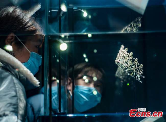 Μια γυναίκα κοιτάζει το «Crown of Bourbon Parma» στην έκθεση κοσμημάτων «Όνειρο του Στέμματος» που πραγματοποιήθηκε στο The Red, στην περιοχή Σανλιτούν στο Πεκίνο, στις 8 Νοεμβρίου 2021. (Φωτογραφία: China News Service)