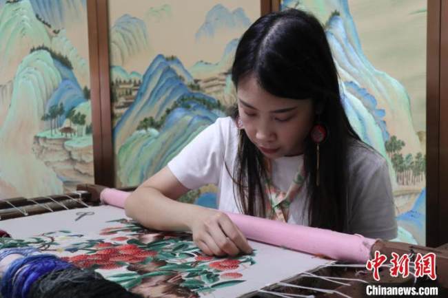 Η Λιανγκ εργάζεται πάνω σε ένα κομμάτι κεντήματος με φρούτα λίτσι. (Chinanews.com)