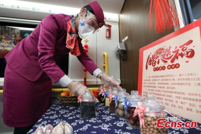 Συνοδός τρένου (乘务员Chéngwùyuán) στο Fuxing EMU (C5980) τακτοποιεί τα συστατικά με τα οποία φτιάχνεται το παραδοσιακό πιάτο της γιορτής Λαμπά, στις 9 Ιανουαρίου 2022. (Φωτογραφία: China News Service)
