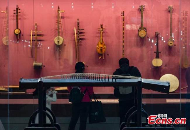 Οι επισκέπτες θαυμάζουν παραδοσιακά κινέζικα μουσικά όργανα από διαδοχικές δυναστείες στο Εθνικό Μουσείο Τεχνών και Χειροτεχνίας της Κίνας που συστεγάζεται με το Μουσείο Άυλης Πολιτιστικής Κληρονομιάς της Κίνας στο Πεκίνο, 8 Φεβρουαρίου 2022. (Φωτογραφία: China News Service/Hou Yu)