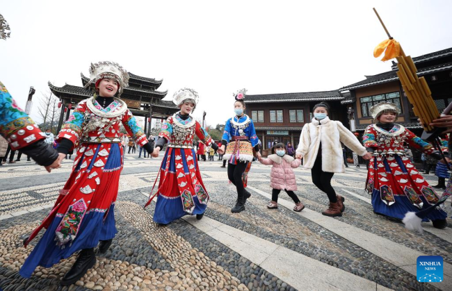 Τουρίστες χορεύουν με κατοίκους της εθνότητας των Μιάο στην κωμόπολη Γουαντά στην αυτόνομη νομό Τσιαντονγκνάν των Μιάο και Ντονγκ, στην επαρχία Γκουιτζόου της νοτιοδυτικής Κίνας, 13 Φεβρουαρίου 2022.