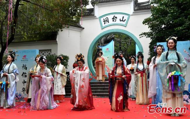 Νεαρές γυναίκες που φορούν χάνφου, την παραδοσιακή ενδυμασία της εθνότητας Χαν, λατρεύουν τον «θεό των λουλουδιών» κατά τη διάρκεια μιας τελετής του Χουατσάο στο γραφικό σημείο του βουνού Γιεντάι στο Φουτζόου, στην επαρχία Φουτζιέν της νοτιοανατολικής Κίνας. (Φωτογραφία: China News Service)