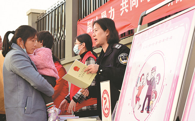 Μέλη μιας γυναικείας ομοσπονδίας ευαισθητοποιούν τον κόσμο για τον νόμο κατά της ενδοοικογενειακής βίας στο Χεφέι, στην επαρχία Ανχούι. [Φωτογραφία Ge Yinian/For China Daily]