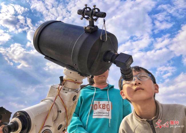 Η φωτογραφία που τραβήχτηκε από τις 12 Μαρτίου 2022, δείχνει παιδιά να παρατηρούν τον ουρανό μέσω ενός τηλεσκοπίου στο Λου’αν της επαρχίας Ανχούι της ανατολικής Κίνας. (Εικόνα/Guangming)