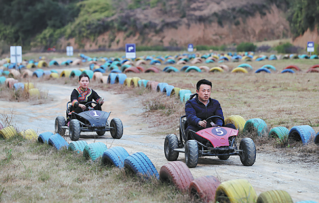 Επισκέπτες απολαμβάνουν αγώνες σε ένα τουριστικό αξιοθέατο στο χωριό Σεζού, Χουιτσάνγκ, Τζιανγκσί. [Φωτογραφία /CHINA DAILY]