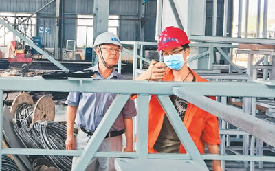 Ο Τζι Γουανρόνγκ (αριστερά) δίνει εντολή σε έναν νεαρό εργάτη να επιθεωρήσει τον εξοπλισμό κατασκευής γεφυρών. (Η φωτογραφία είναι ευγενική προσφορά του συνεντευξιαζόμενου)