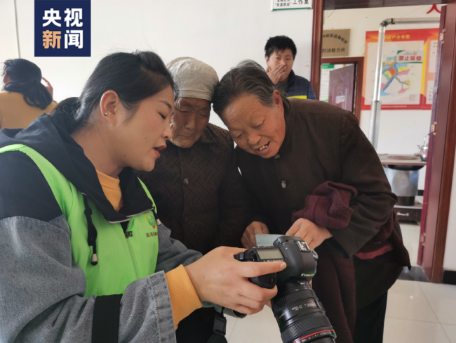Η φωτογραφία δείχνει ηλικιωμένους χωρικούς να διαλέγουν τις αγαπημένες τους φωτογραφίες που τραβήχτηκαν στην κάμερα της Γιανγκ. (Φωτογραφία/CCTV)