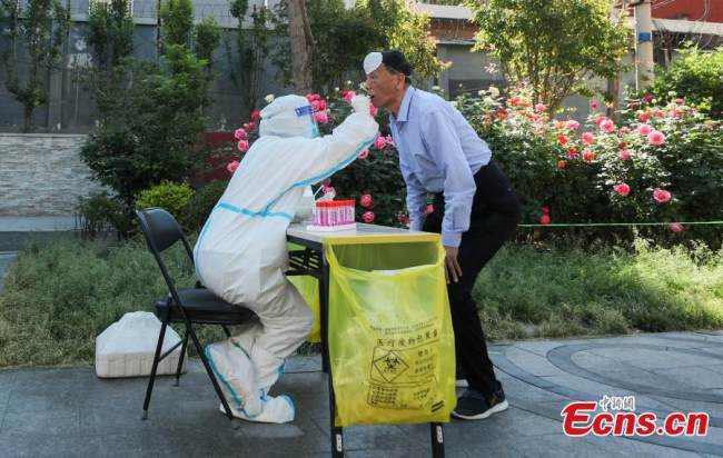 Ένας άνδρας υποβάλλεται σε δοκιμή νουκλεϊκού οξέος στην συνοικία Σανλιτούν της περιοχής Τσαογιάνγκ στην πρωτεύουσα της Κίνας, στις 15 Μαΐου 2022.. (Φωτογραφία: China News Service/Jia Tianyong)