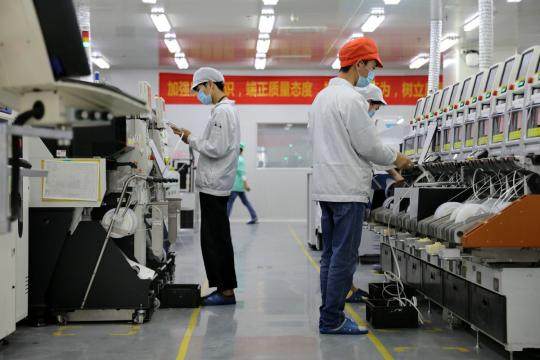 Εργαζόμενοι ελέγχουν τον εξοπλισμό παραγωγής σε ένα εργοστάσιο Sunwoda στο Σεντζέν της επαρχίας Γκουανγκντόνγκ. (Φωτογραφία/Xinhua)