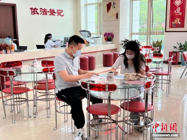 Ένα ζευγάρι εγγράφεται σε ένα κέντρο εγγραφής γάμων στην περιοχή Τσαομίνγκ, στη Σαγκάη της ανατολικής Κίνας, στις 20 Μαΐου 2022. (Φωτογραφία: China News Service/)