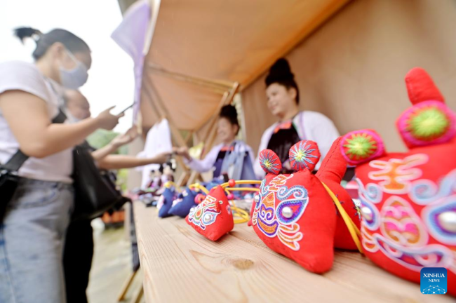 Άνθρωποι επιλέγουν κεντητά προϊόντα σε μια αγορά στην κομητεία Τσονγκτζιάνγκ της αυτόνομης περιφέρειας Τσιενντονγκνάν Μιάο και Ντονγκ, στην επαρχία Γκουιτζόου της νοτιοδυτικής Κίνας, 11 Ιουνίου 2022.