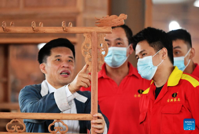 Ο Τσεν Γιουσού (1ος αριστερά) εξηγεί την κλασική κινεζική επιπλοποιία στα μέλη της ομάδας του σε ένα εργαστήριο κατασκευής επίπλων στο Πουτιέν, στην επαρχία Φουτζιέν της νοτιοανατολικής Κίνας, 10 Ιουνίου 2022.