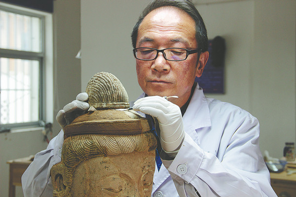 Ερευνητές από την Ακαδημία Ντουνχουάνγκ ενώ εργάζονται για την αποκατάσταση των αγαλμάτων και των τοιχογραφιών των Σπηλαίων Τιεντινσάν σε φωτογραφία από το 2017. Το πρόγραμμα διατήρησης ολοκληρώθηκε τον Ιούνιο. [Φωτογραφία/China Daily]