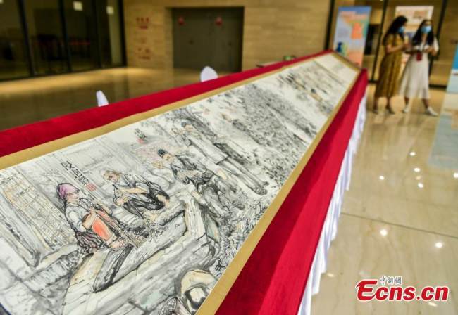 Ένας πίνακας μήκους 16 μέτρων σε χαρτί από φλοιό μουριάς εκτίθεται κατά τη διάρκεια μιας έκθεσης άυλης πολιτιστικής κληρονομιάς στο Μουσείο Τέχνης Σιντζιάνγκ, στην πρωτεύουσα Ουρούμτσι της αυτόνομης περιοχής Σιντζιάνγκ Ουιγκούρ της βορειοδυτικής Κίνας, 31 Ιουλίου 2022. 
