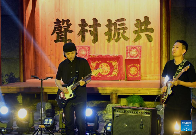 Μέλη ενός ροκ συγκροτήματος δίνουν παράσταση στο χωριό Ντανανπό της κομητείας Χιουγού στην πόλη Τζιαοζουό, στην επαρχία Χενάν της κεντρικής Κίνας 31 Ιουλίου 2022. 
